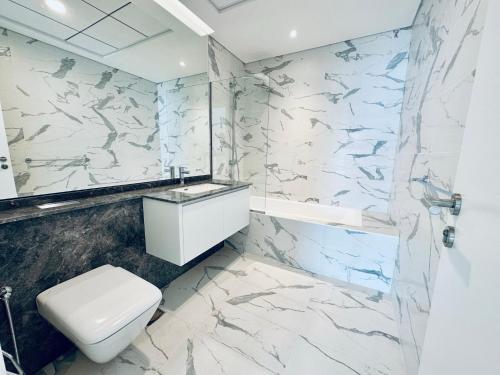 阿布扎比Brand New Full Apartment Next to Reem Mall的浴室配有白色卫生间和大理石墙。