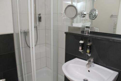菲尔德施塔特海尔施花园酒店的带淋浴、盥洗盆和镜子的浴室
