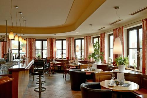 新锡德勒湖畔普巴赫Hotel & Restaurant Braunstein - Pauli´s Stuben的餐厅设有桌椅和窗户。