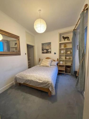 爱丁堡Welcoming Morningside Escape的一间卧室配有一张床和吊灯
