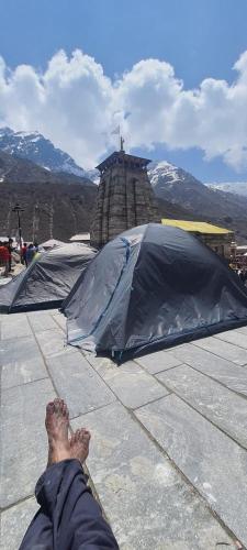 KedārnāthKedarnath Shiva Camps - TraOwl的躺在黑伞旁的人