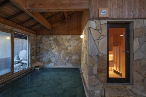 南小国町Kyutei的一座石墙房子内的游泳池