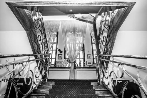 卡利什施塔卡利什别墅酒店的走廊上设有楼梯,配有窗帘和楼梯