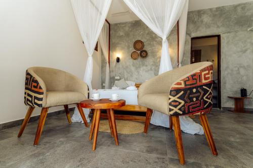 江比阿撒维拉海滩别墅的房间里的两张椅子和一张桌子