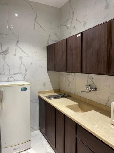 塞卡凯فندق الحنوة的厨房配有木制橱柜和白色冰箱。