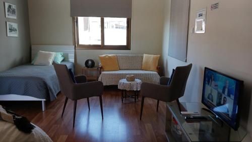 拉纳卡Extremely comfy apt with spacious private terrace 10min walk to the beach & in Town的客厅配有床、椅子和电视