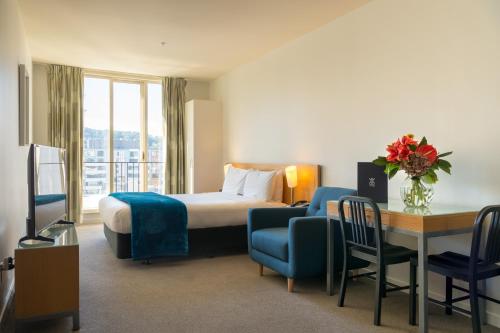 惠灵顿阿斯特里亚公寓酒店的一张床铺、一张桌子和一张床