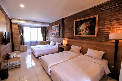 万隆Ciwidey Valley Resort Hot Spring Waterpark的酒店客房带两张床和砖墙