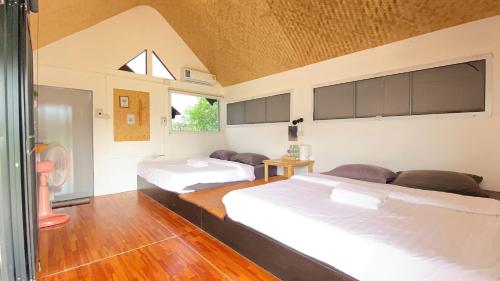 Ban Noiบ้านติดดิน รีสอร์ท เชียงคาน的一间卧室设有两张床和窗户。