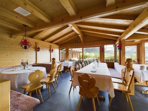 阿峙奇Bergblick Lodge - 3 Sterne Garni - Neueröffnung的用餐室设有桌椅和窗户。