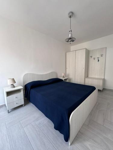 帕利努罗La casetta Mare的一间卧室配有一张带蓝色毯子的大床