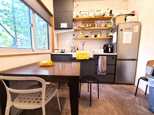 首尔Seoul Cube Itaewon的厨房配有木桌和冰箱。