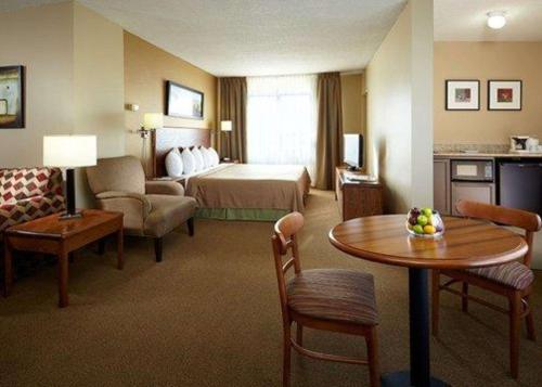 多瓦尔P.E蒙特利尔特鲁多机场品质套房酒店的酒店客房带一张床、一张桌子和椅子