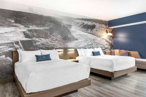 尼亚加拉瀑布Cambria Hotel Niagara Falls的墙上画画的房间里设有两张床
