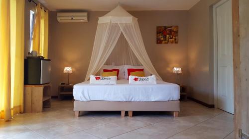 威廉斯塔德芙蓉海滨民宿的一间卧室配有一张带天蓬的白色床