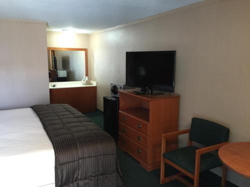 圣罗伯圣罗伯特经济酒店 的酒店客房设有床、电视和桌子。