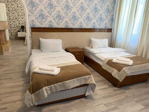 巴库Prestige Vintage Hôtel的一间卧室配有两张带毛巾的床