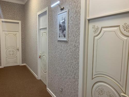 巴库Prestige Vintage Hôtel的走廊上设有白色门,墙上挂着一幅画