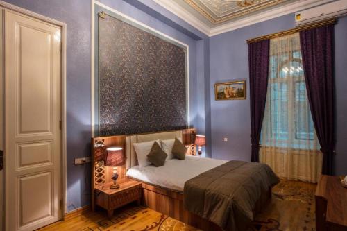 巴库Prestige Vintage Hôtel的蓝色客房中一间带床的卧室