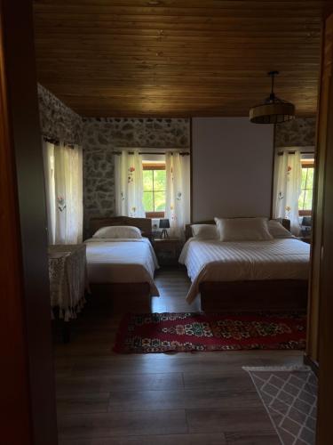 泰斯Molla Guest House的一间卧室设有两张床和石墙