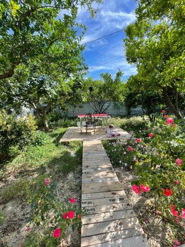 培拉特Guest house Luli Strumi的花园中带桌子和鲜花的走道