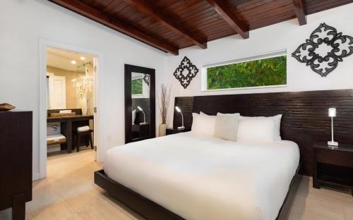 基拉戈Largo Resort的卧室配有一张白色大床和一张书桌