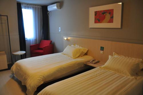 萧山锦江之星萧山国际机场店的酒店客房,设有两张床和一张红色椅子