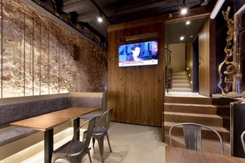 塔拉戈纳诺里亚旅馆的餐厅设有桌椅和墙上的电视