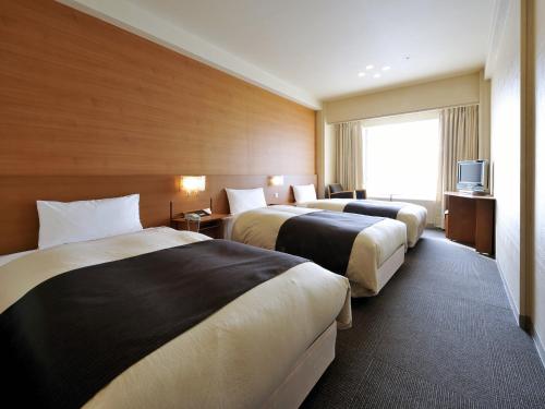 北九州北九州皇冠饭店的酒店客房设有两张床和电视。