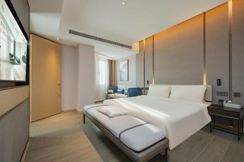 嘉定上海嘉定菊园智慧中心亚朵酒店的卧室配有一张白色大床和电视。