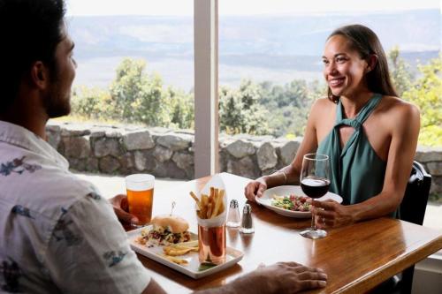 沃尔卡诺Volcano House的坐在餐桌上吃一盘食物的男人和女人