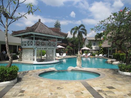 塞米亚克塞米亚克阿南达度假酒店的一座位于中间的带雕像的度假村的游泳池