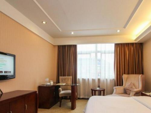 杭州Vienna Hotel Hangzhou Binkang Road Metro Station的酒店客房,配有床和电视