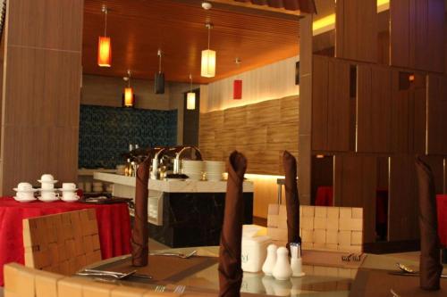 SengkuangThe Golden Bay Hotel Batam的厨房配有柜台和桌子及餐具