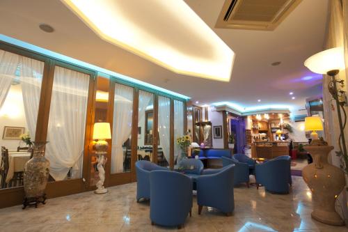 索托马里纳美杜莎酒店的酒店大堂设有蓝色的桌椅和客房