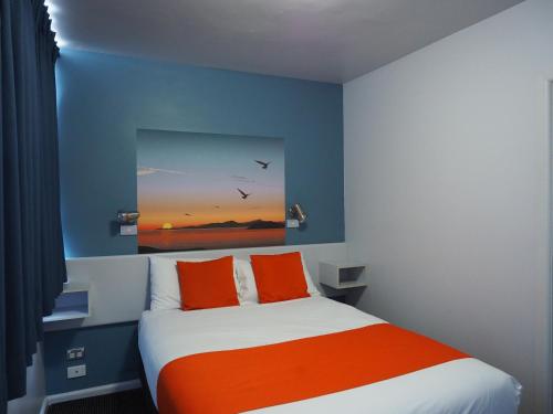 霍巴特海滨洛奇汽车旅馆的一间卧室配有橙色和蓝色墙壁的床
