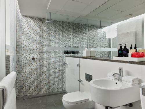 悉尼Hotel Woolstore 1888, Sydney - Handwritten Collection的白色的浴室设有水槽和卫生间。