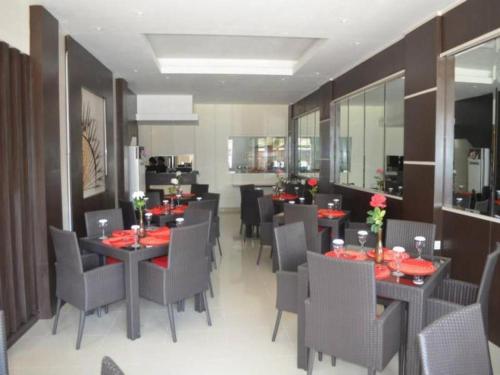 索龙Belagri Hotel And Restaurant的餐厅内带桌椅的用餐室