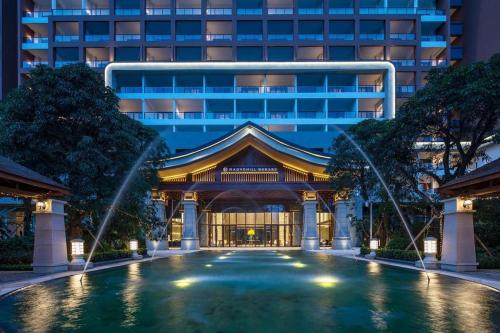 花都Guangzhou Rongchuang Jingshan Hotel的建筑前有水池的建筑