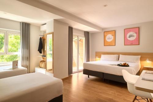 瓦伦西亚科学旅馆的酒店客房设有两张床、一张桌子和一张书桌。