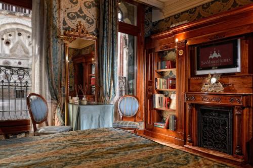 威尼斯Bellevue Luxury Rooms - San Marco Luxury的一间卧室配有一张床和一个壁炉