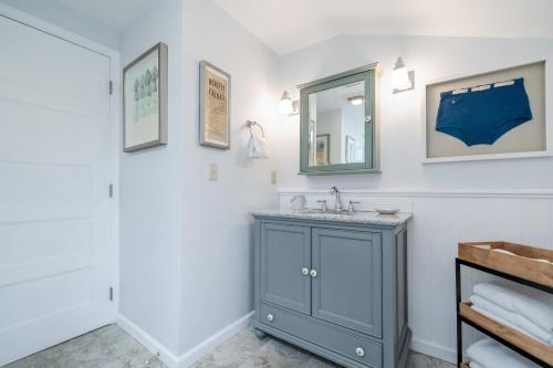 西塞德Sand Dollar Cottage的浴室设有蓝色橱柜和镜子
