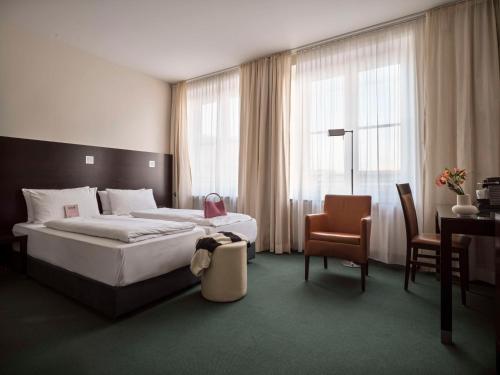 慕尼黑Flemings Hotel München-City的一间卧室配有一张床、一张桌子和一把椅子