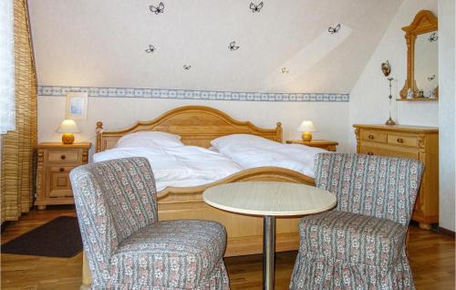 HausenLovely Home In Oberaula-hausen With Wifi的一间卧室配有一张带桌子和两把椅子的床