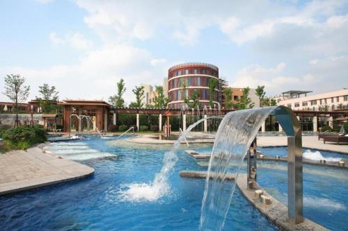 XinqiaoSuzhou Phoenix Hotspring Resort的一个带水上滑梯的水上公园的游泳池