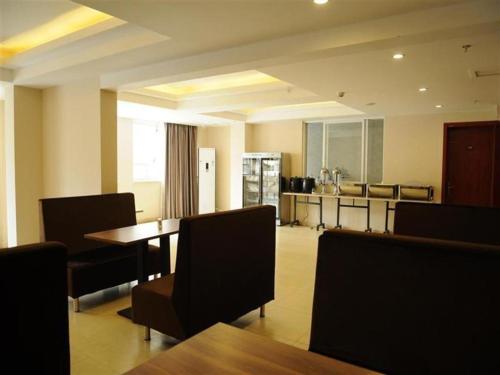 成都GreenTree Inn Chengdu North Railway Station Beichengtianjie Business Hotel的一间带桌椅的用餐室和一间厨房