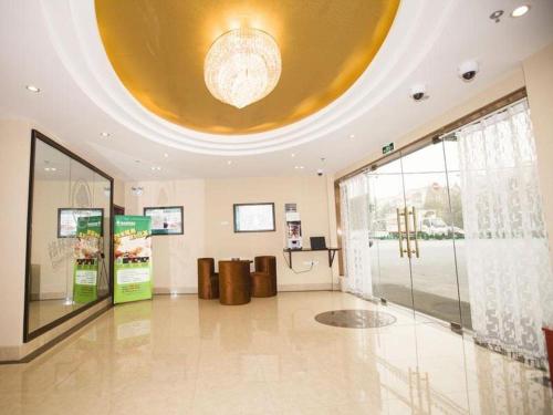 上海GreenTree Inn Shanghai Hongqiao Airport Huqingping Highway Shell Hotel的大堂设有大型天花板和大型玻璃门