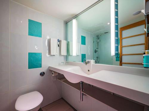 伦敦诺富特伦敦西区酒店的一间带水槽、卫生间和镜子的浴室