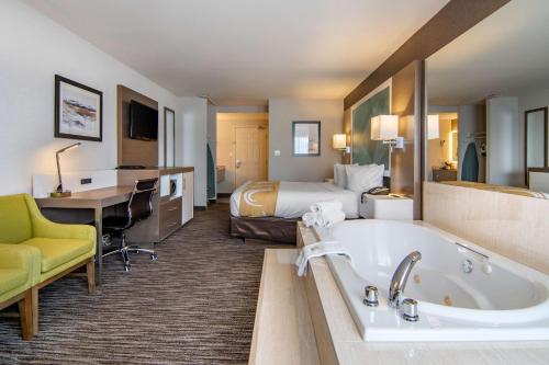 坎卢普斯坎卢普斯优质酒店的酒店客房配有一张床和浴缸。