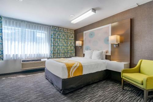 坎卢普斯坎卢普斯优质酒店的酒店客房设有一张大床和一张黄色椅子